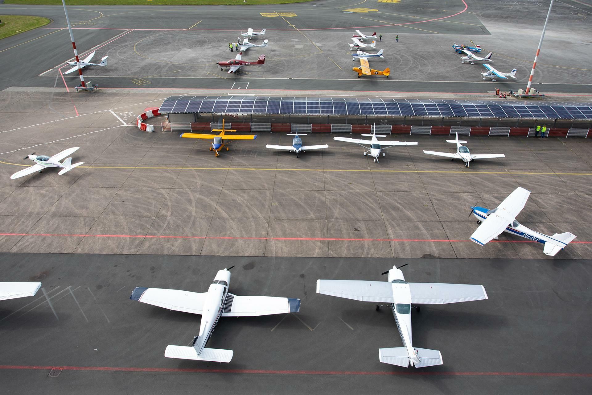 Kleine vliegtuigen geparkeerd op een vliegveld.